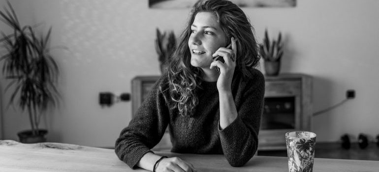 A woman on a phone, contacting long distance moving companies Maryland.