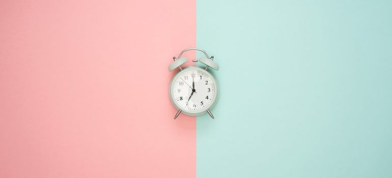 A clock on a pink and blue surface.