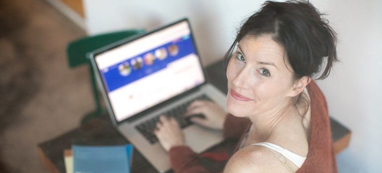 A woman on her computer looking for movers Olney MD