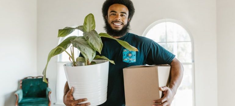 Potomac MD mover holding a box and a plant